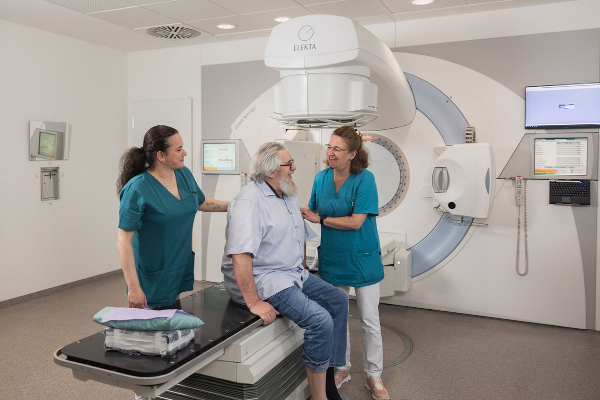 Patient mit Arzthelferinnen im Behandlungsraum